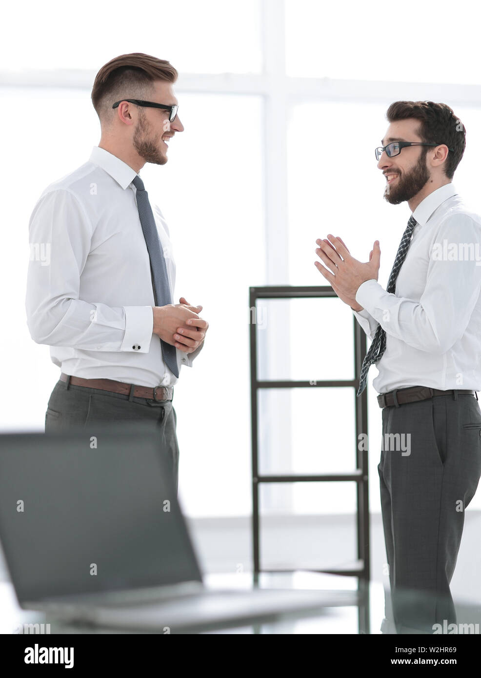 two businessmen talking standing in the office Stock Photo - Alamy