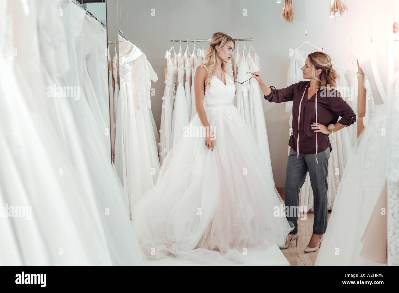 Tailor giving young woman advice about her dress. Stock Photo
