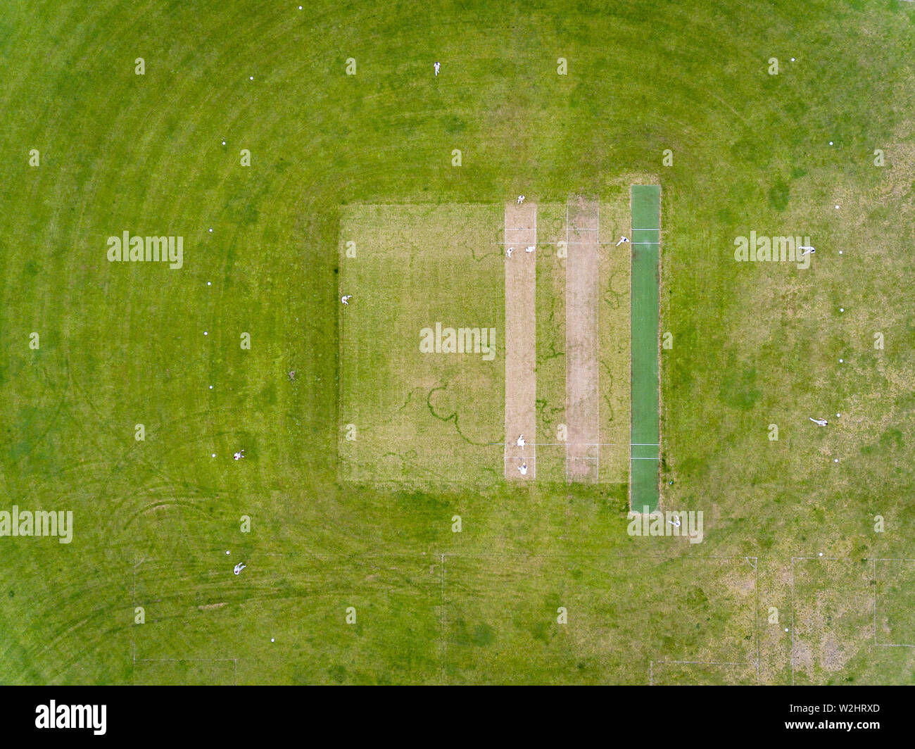 Aerial view of players, playing a game of Cricket on a Welsh Park Pitch in the summer Stock Photo