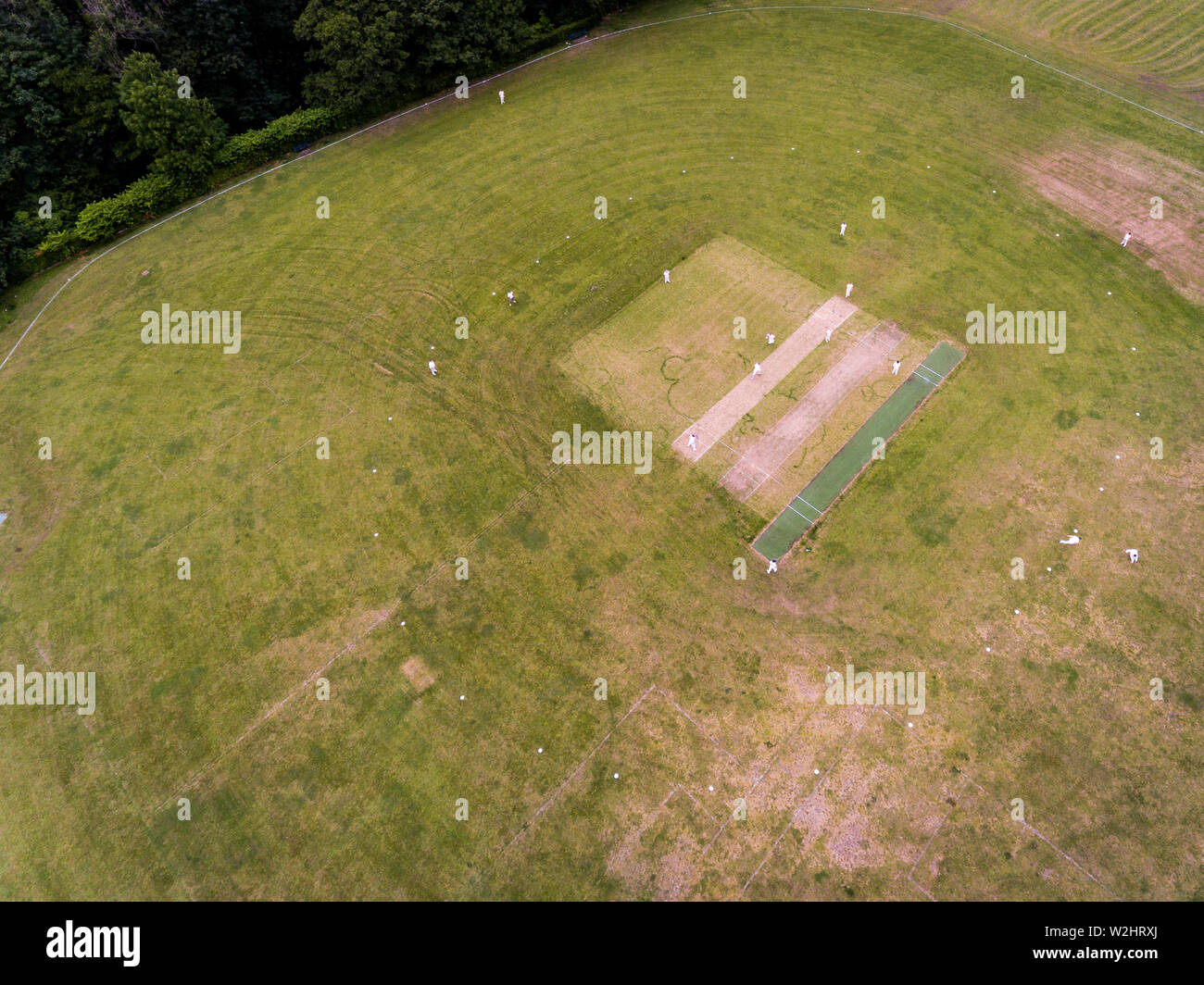 Aerial view of players, playing a game of Cricket on a Welsh Park Pitch in the summer Stock Photo