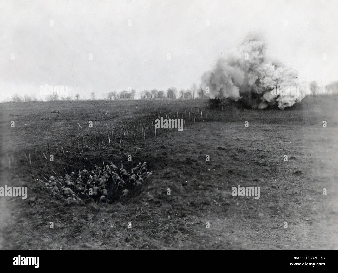 Re-acting a scene which took place during a fight of Argonne. In the foreground, a large shell-hole provides shelter for first wave of advancing engineers. In background, blowing up barbed wire entanglements to make a passage for infantry. Rupt Le Grande, Meuse, France Stock Photo
