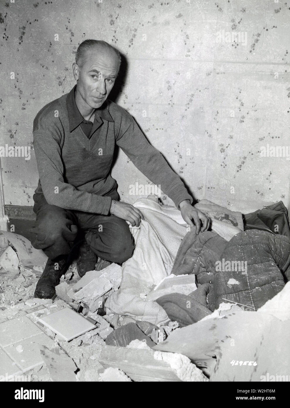Bomb that hit PRO today aslo hurt some of the war correspondents, among whom was Ernie Pyle. He suffered a slight cut on the face and is here looking at his bed from which he had just left to watch the bombing when the roof fell on it Stock Photo