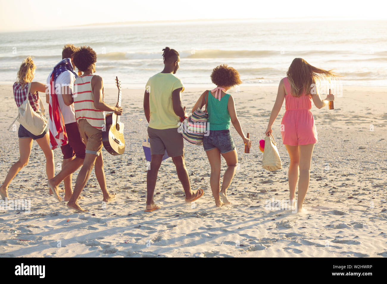 Group of friends walking together on the beach Stock Photo - Alamy