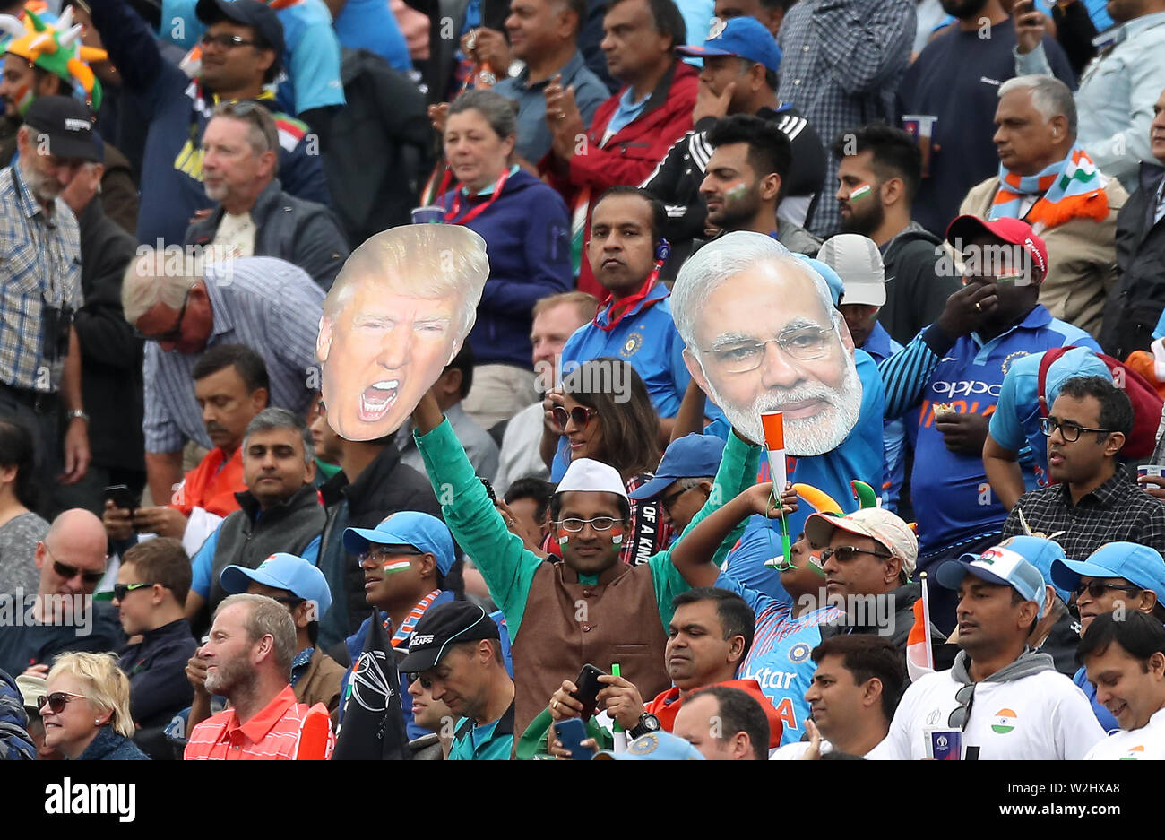 Fan holds up masks of American President Donald Trump (left) and Prime