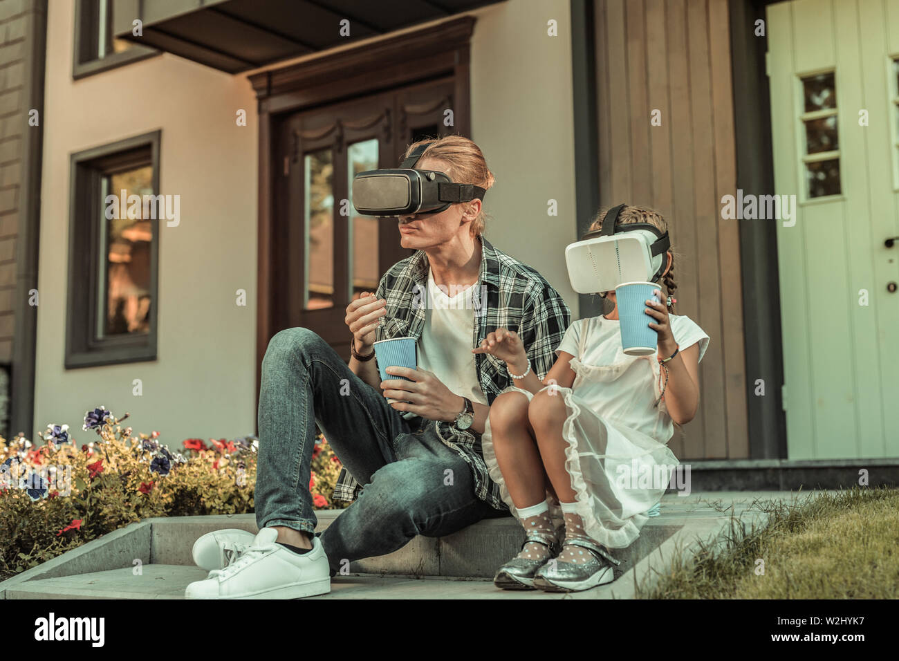 Modern blonde father sitting on the porch with his daughter Stock Photo