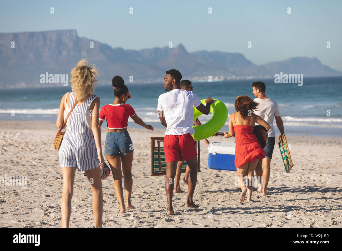 Group of friends walking together on the beach Stock Photo - Alamy