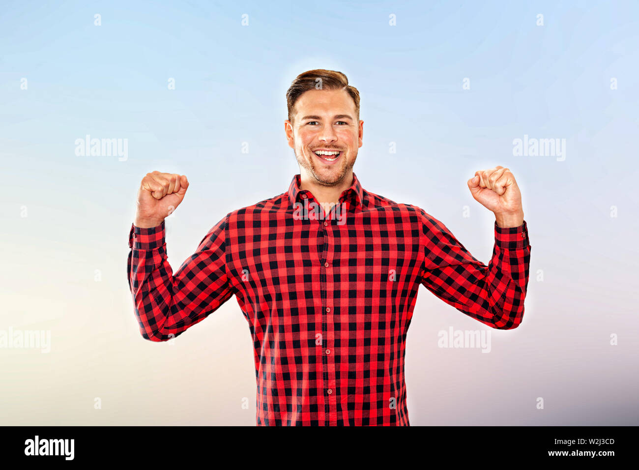 Exultant man cheering a personal success laughing and pumping the air ...