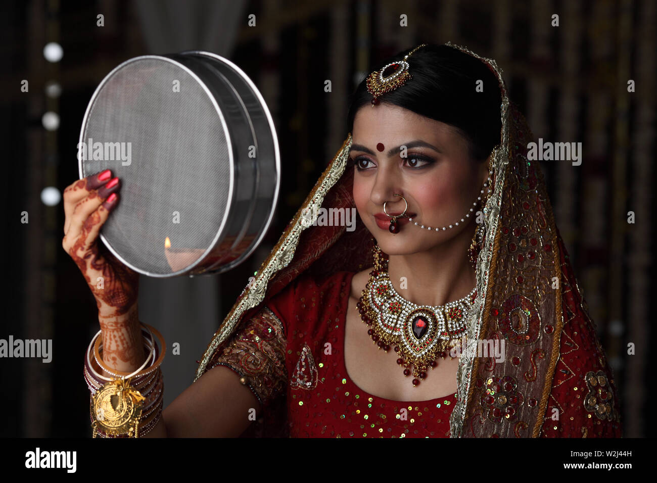 Indian woman looking through sieve during karwa chauth Stock Photo ...