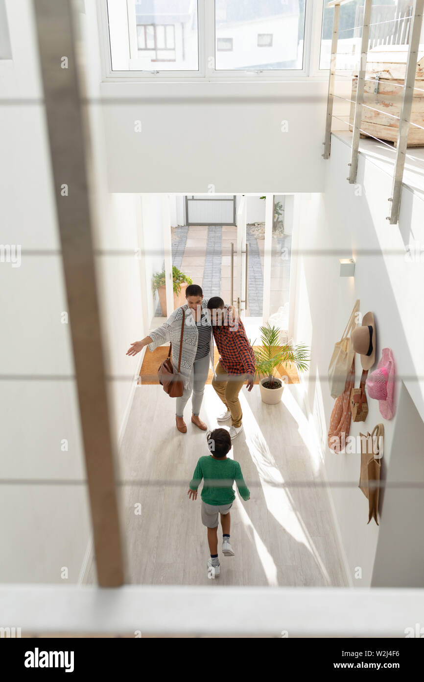 Parents embracing their son while entering at home Stock Photo