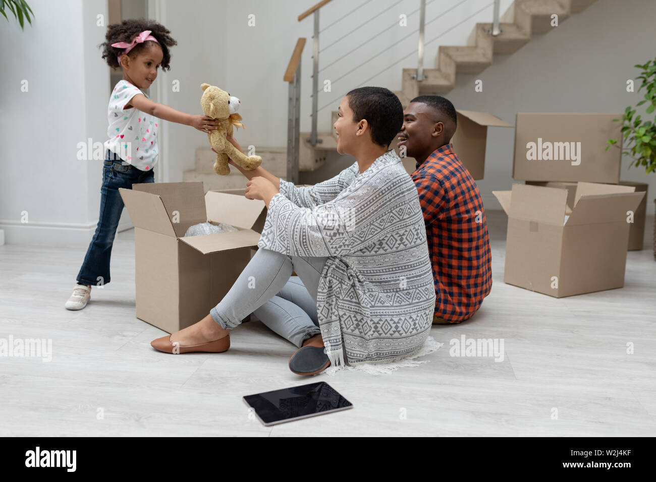 Girl giving teddy bear to mother in living room at home Stock Photo - Alamy