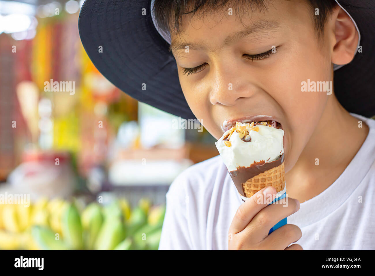 A Boy Wearing A White Shirt Is Eating Ice Cream Stock Photo