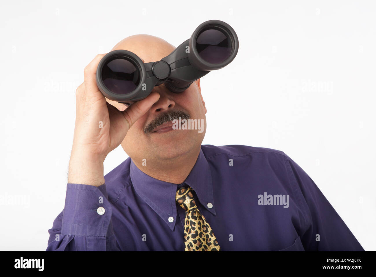 Businessman looking through binoculars Stock Photo