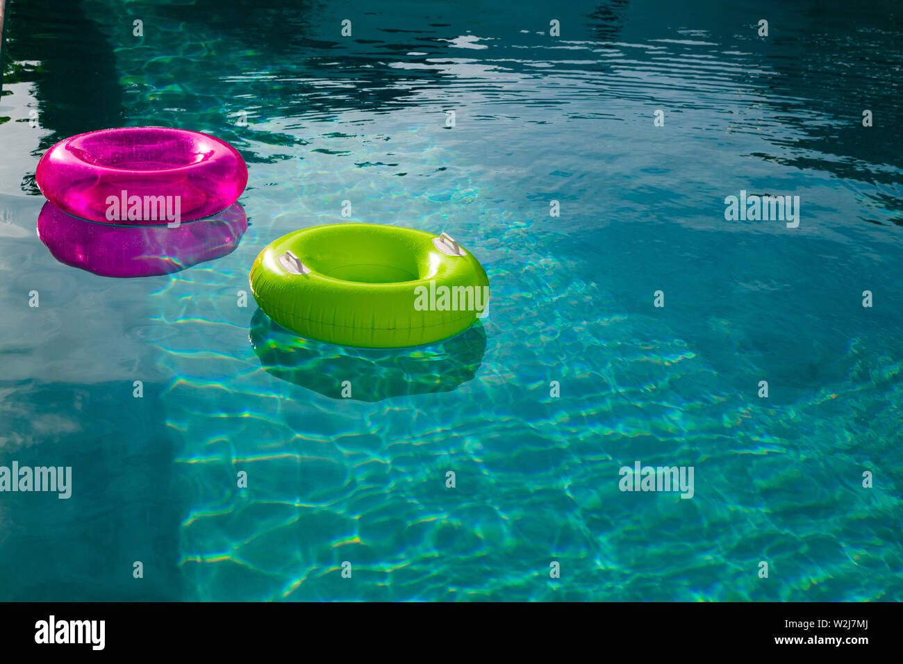 Inflatable tubes floating in a swimming pool in backyard Stock Photo