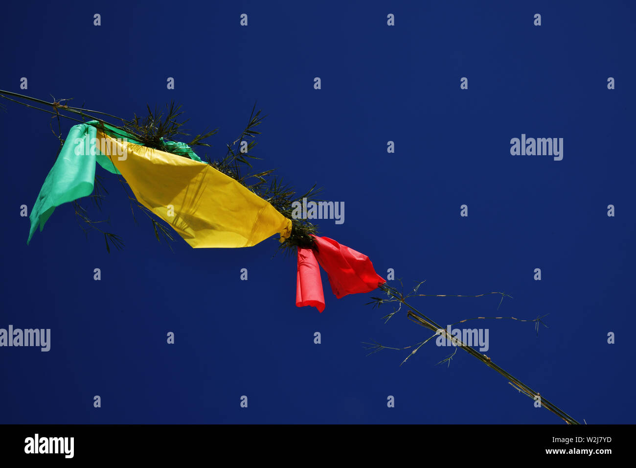 Green, yellow and red flags on blue sky in Brazil Stock Photo
