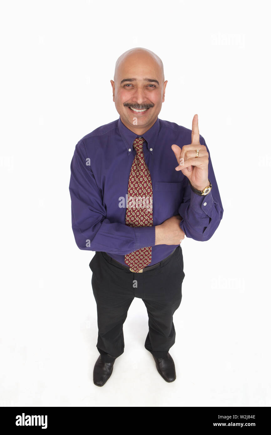 Portrait of a businessman pointing upward and smiling Stock Photo
