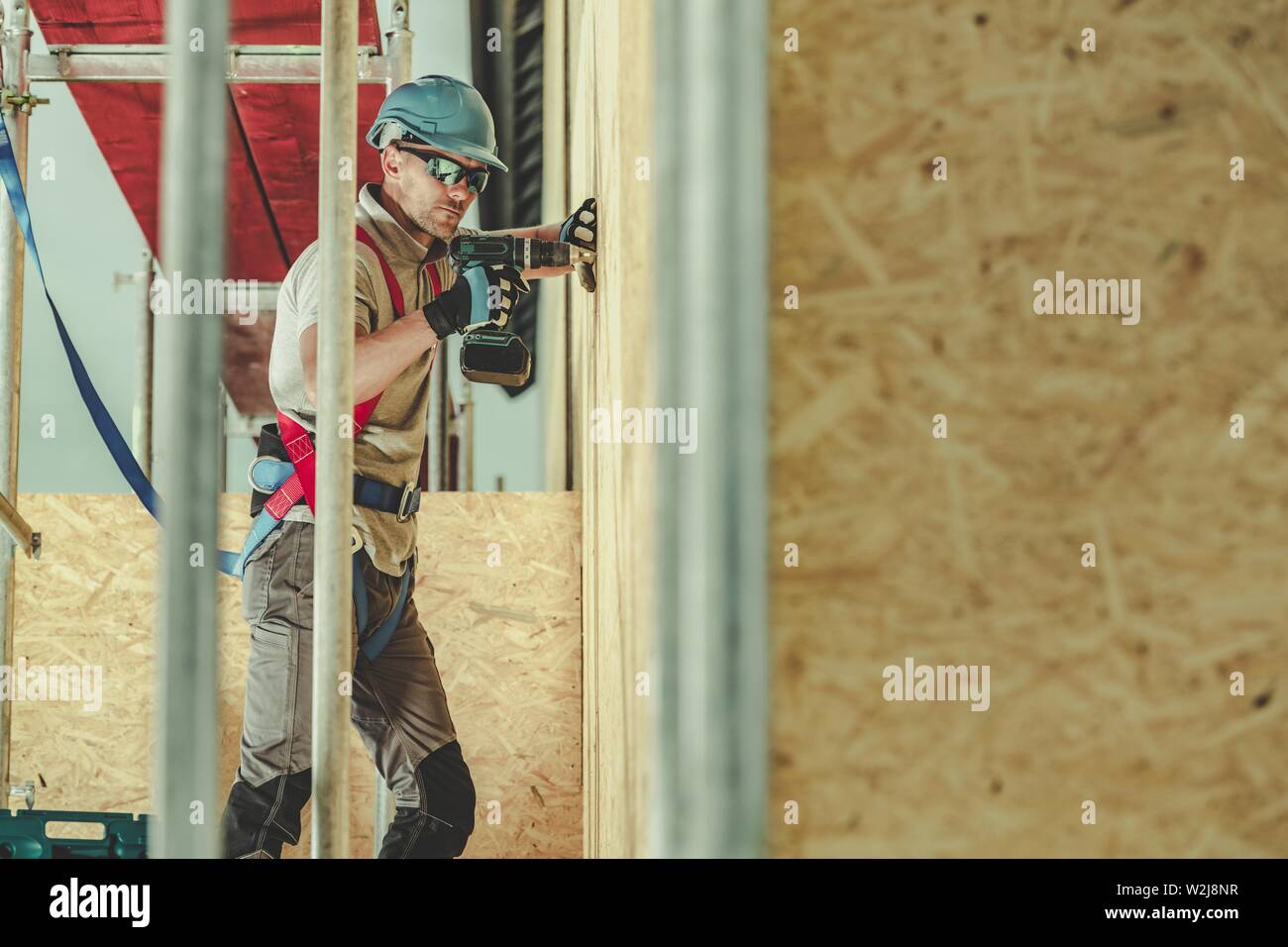 Construction Day Job. Caucasian Worker on a Scaffolding During Working Hours. Labor Theme. Stock Photo