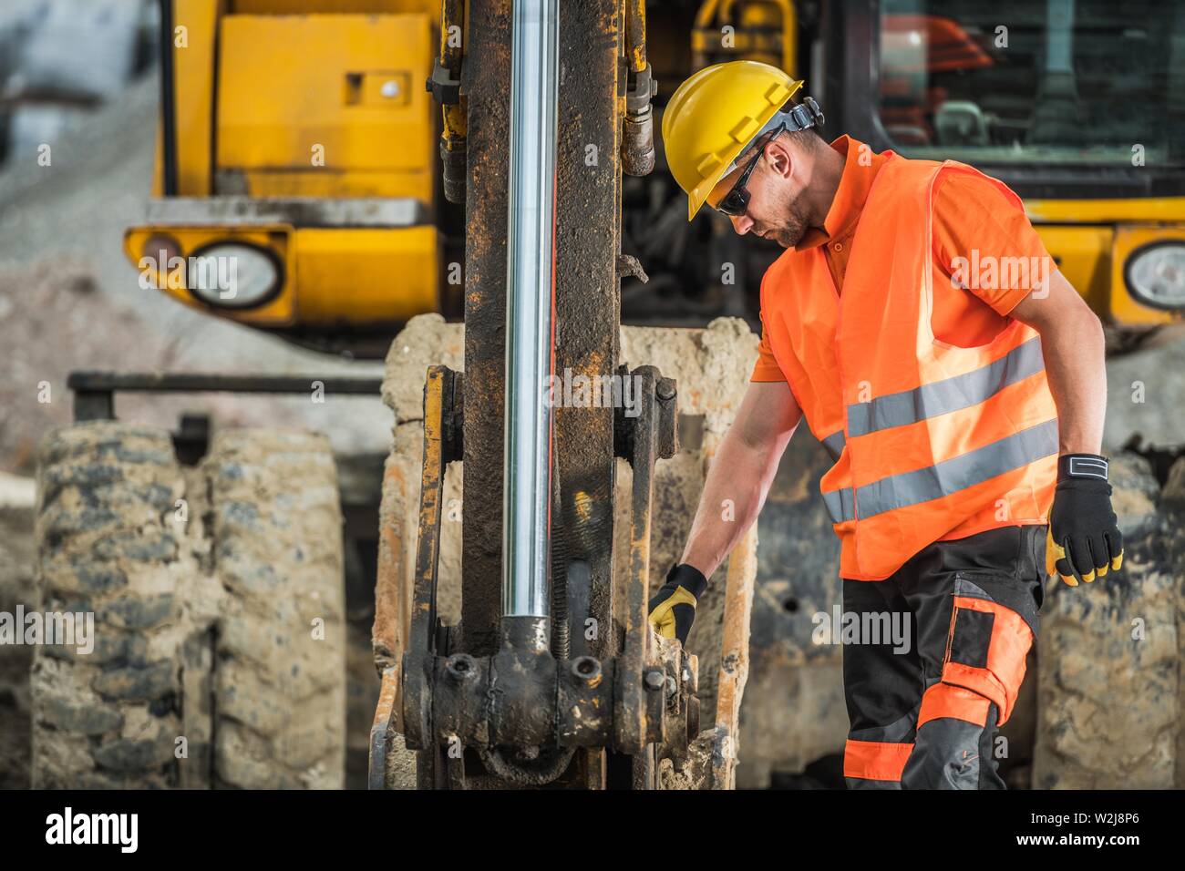 Construction Excavation Works. Caucasian Excavator Operator in His 30s. Industrial Theme. Stock Photo