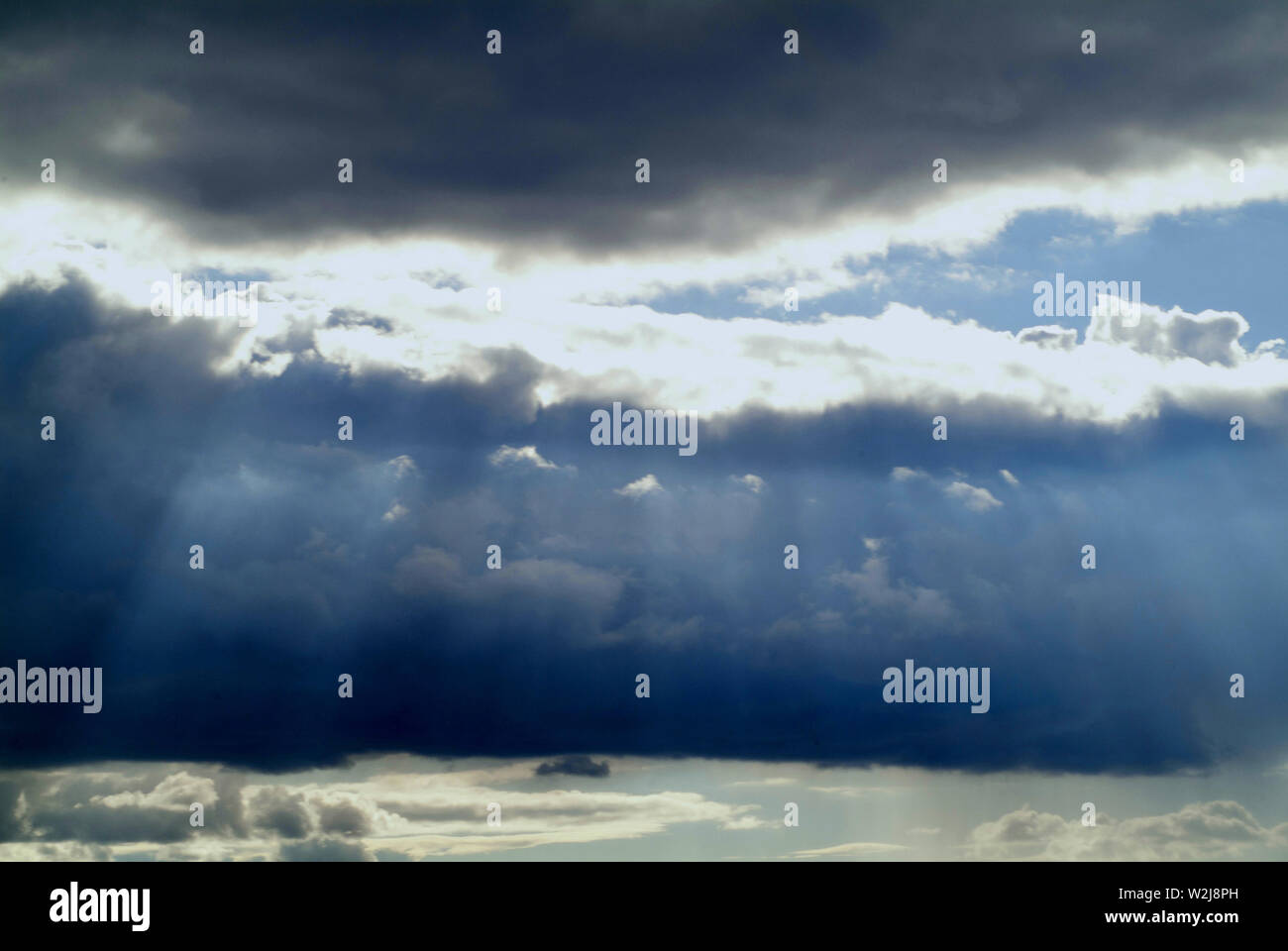SUNSCREEN: Clouds in a distant Virginia sky filter the sunrays through a dramatic cloudscape down to the earth. Stock Photo