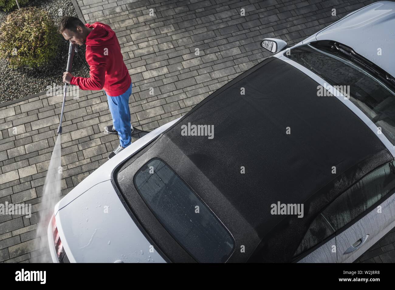 Convertible Car Pressure Wash by Caucasian Men. Front Yard Vehicle Maintenance. Automotive Theme. Stock Photo