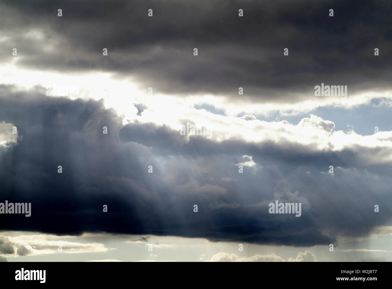 SUNSCREEN: Clouds in a distant Virginia sky filter the sunrays through a dramatic cloudscape down to the earth. Stock Photo