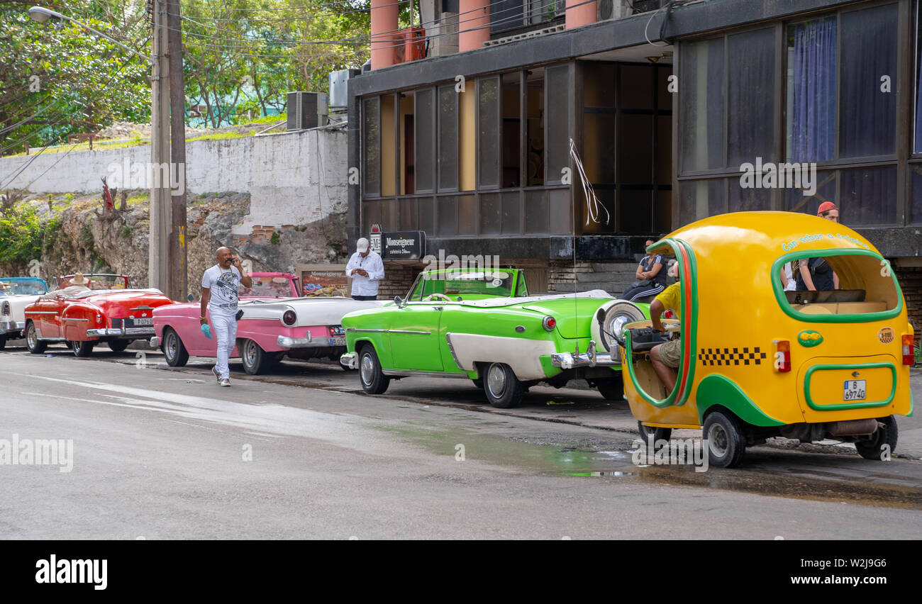 Havana, Cuba - December  31, 2018: Cuban taxi drivers await in their classic American cars for potential customers. Stock Photo