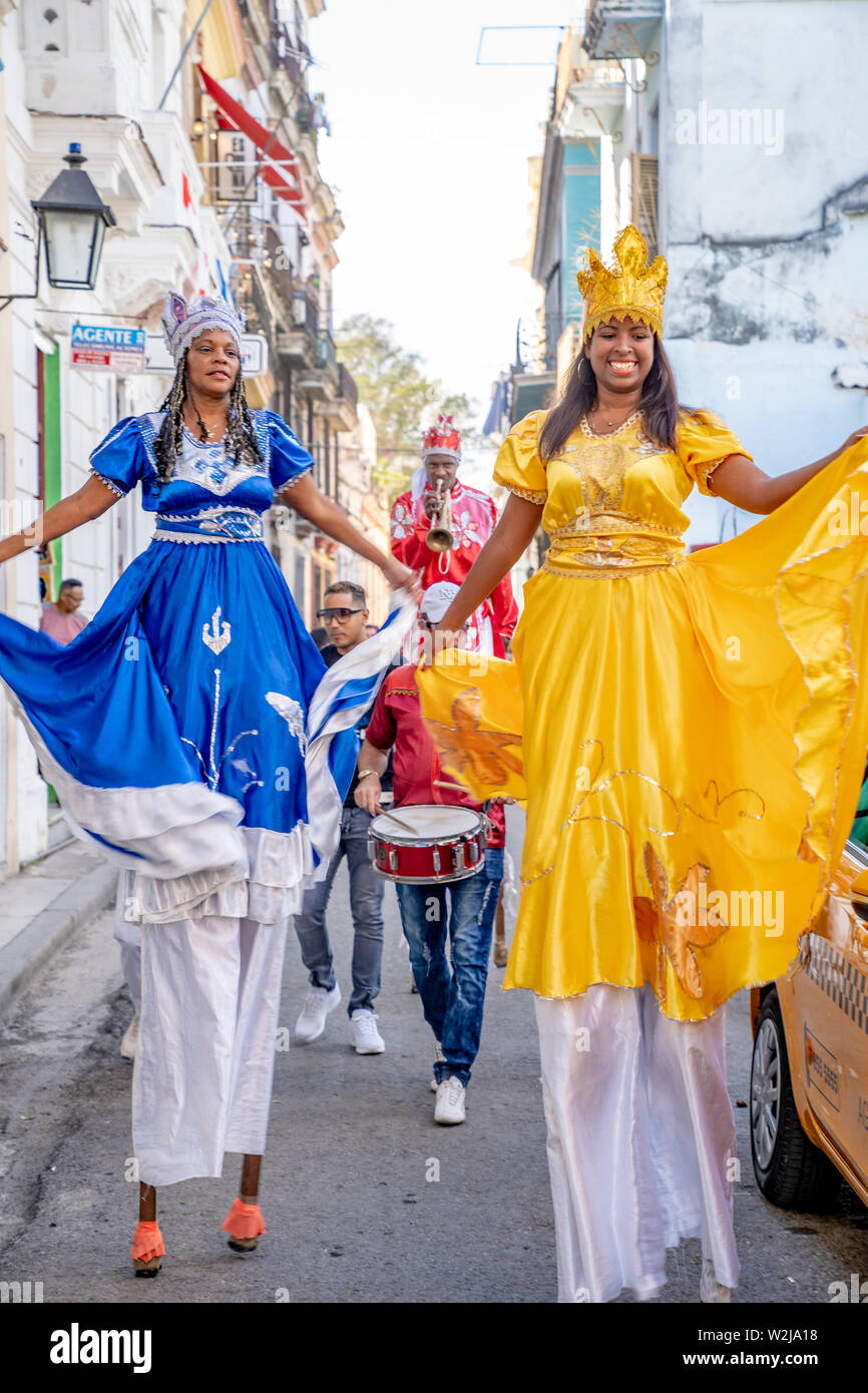 Old Havana, Cuba - January 2, 2019: Stilts performers and musicians start an impromptu street party in the streets of Havana. Stock Photo