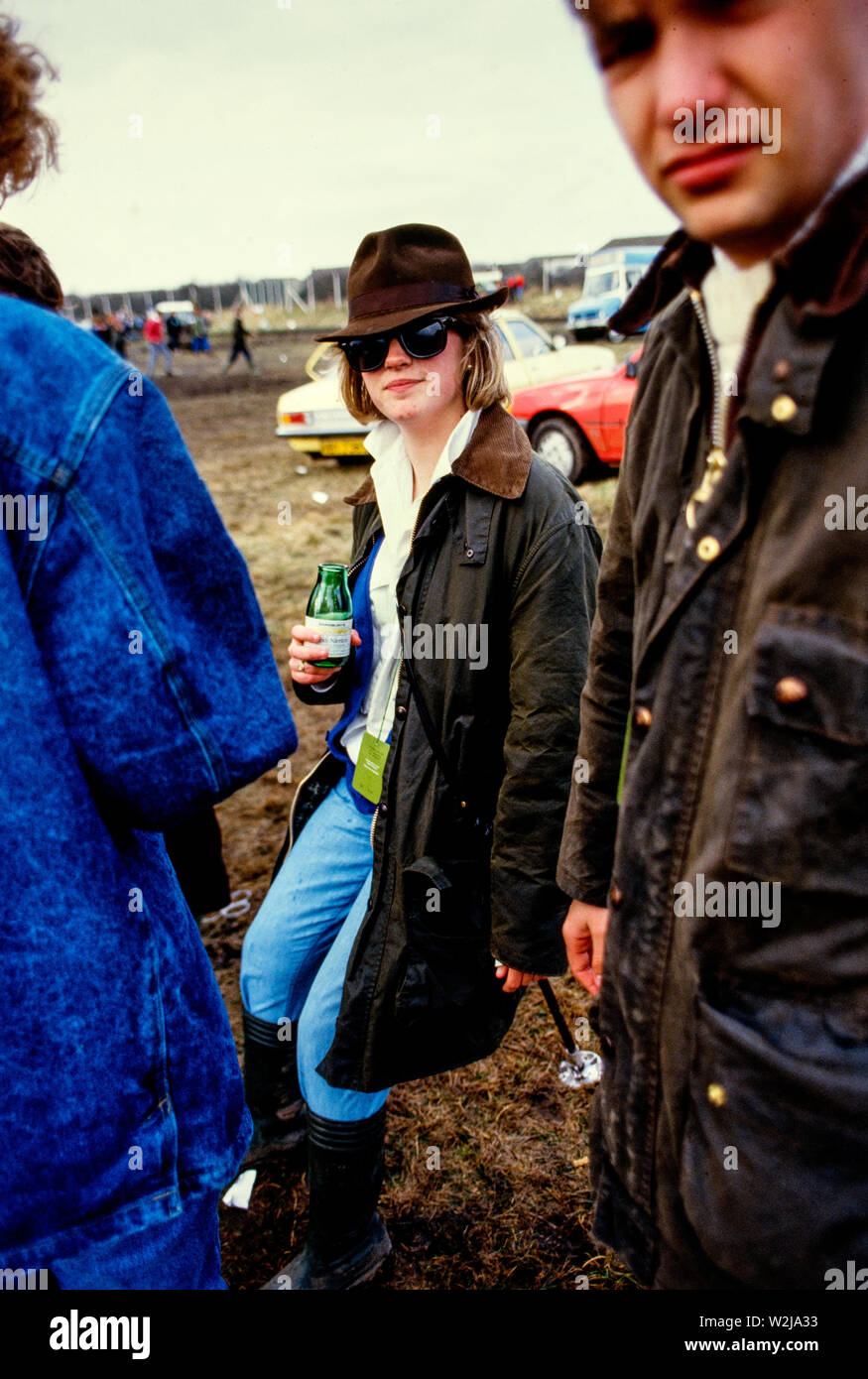 Grand National Horse Race at Aintree, Liverpool 1986. Scanned in 2018 Visitors at the Grand National Horse Race in 1986. Punters studying the form, young men and women. This was the period of 'Hooray Henrys', rich young city types who travelled up to Liverpool for a good boozy day out. Stock Photo