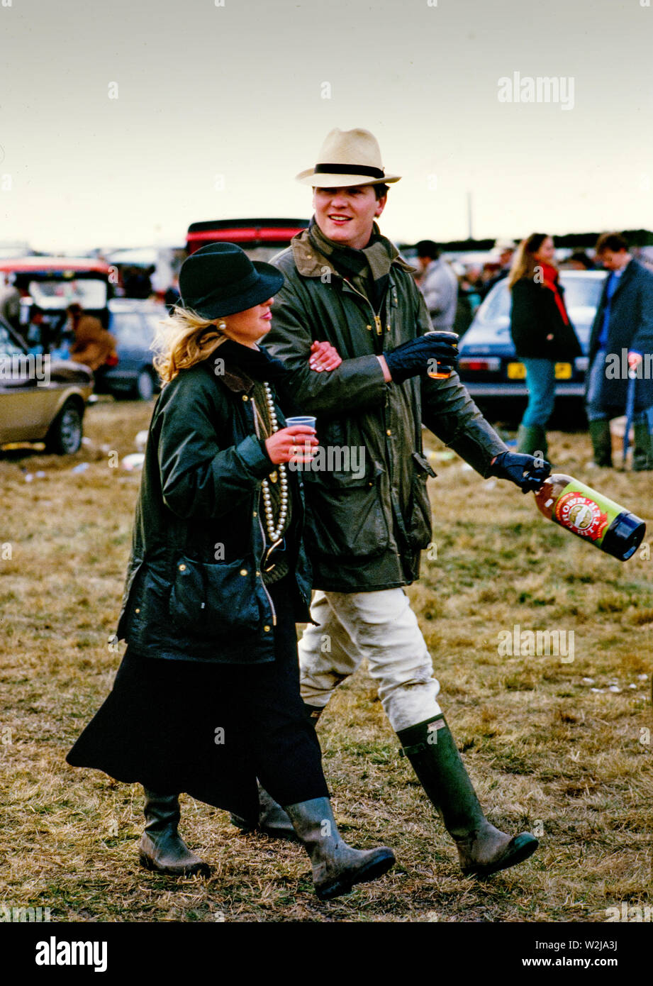 Grand National Horse Race at Aintree, Liverpool 1986. Scanned in 2018 Visitors at the Grand National Horse Race in 1986. Punters studying the form, young men and women. This was the period of 'Hooray Henrys', rich young city types who travelled up to Liverpool for a good boozy day out. Stock Photo