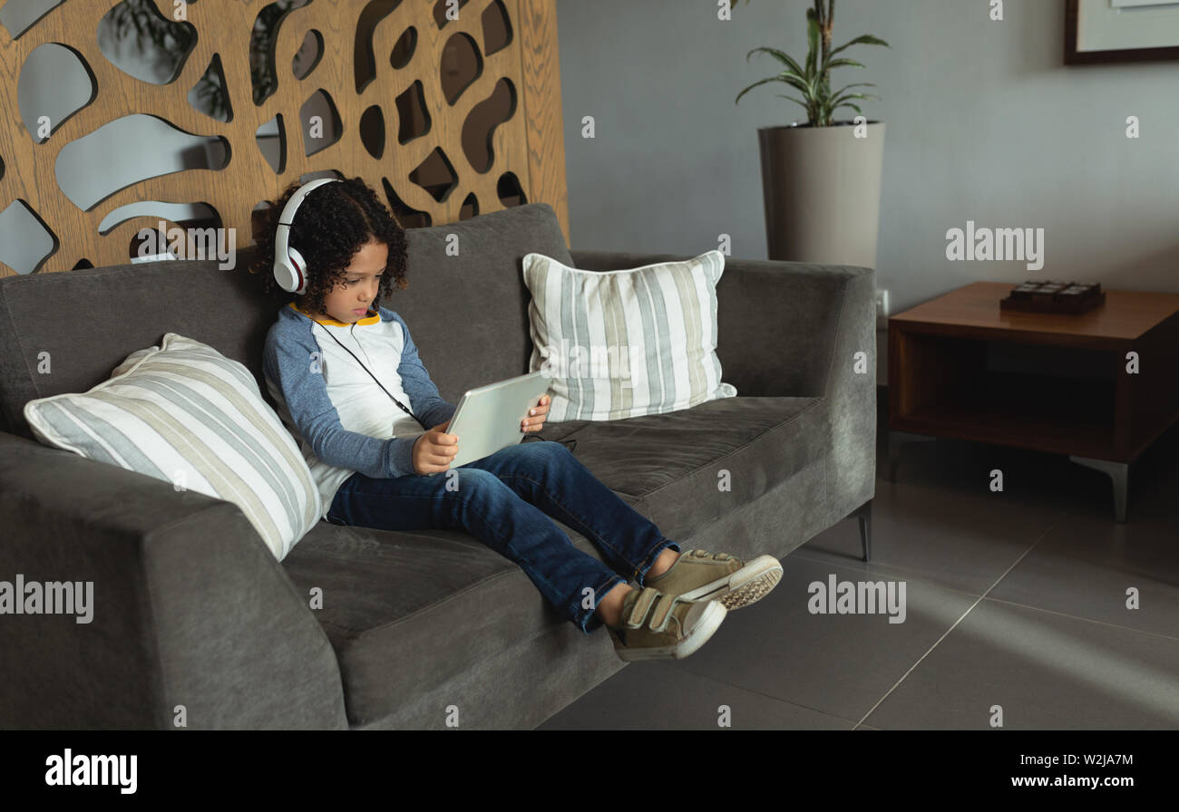 Boy listening music on digital tablet in the lobby at hospital Stock Photo