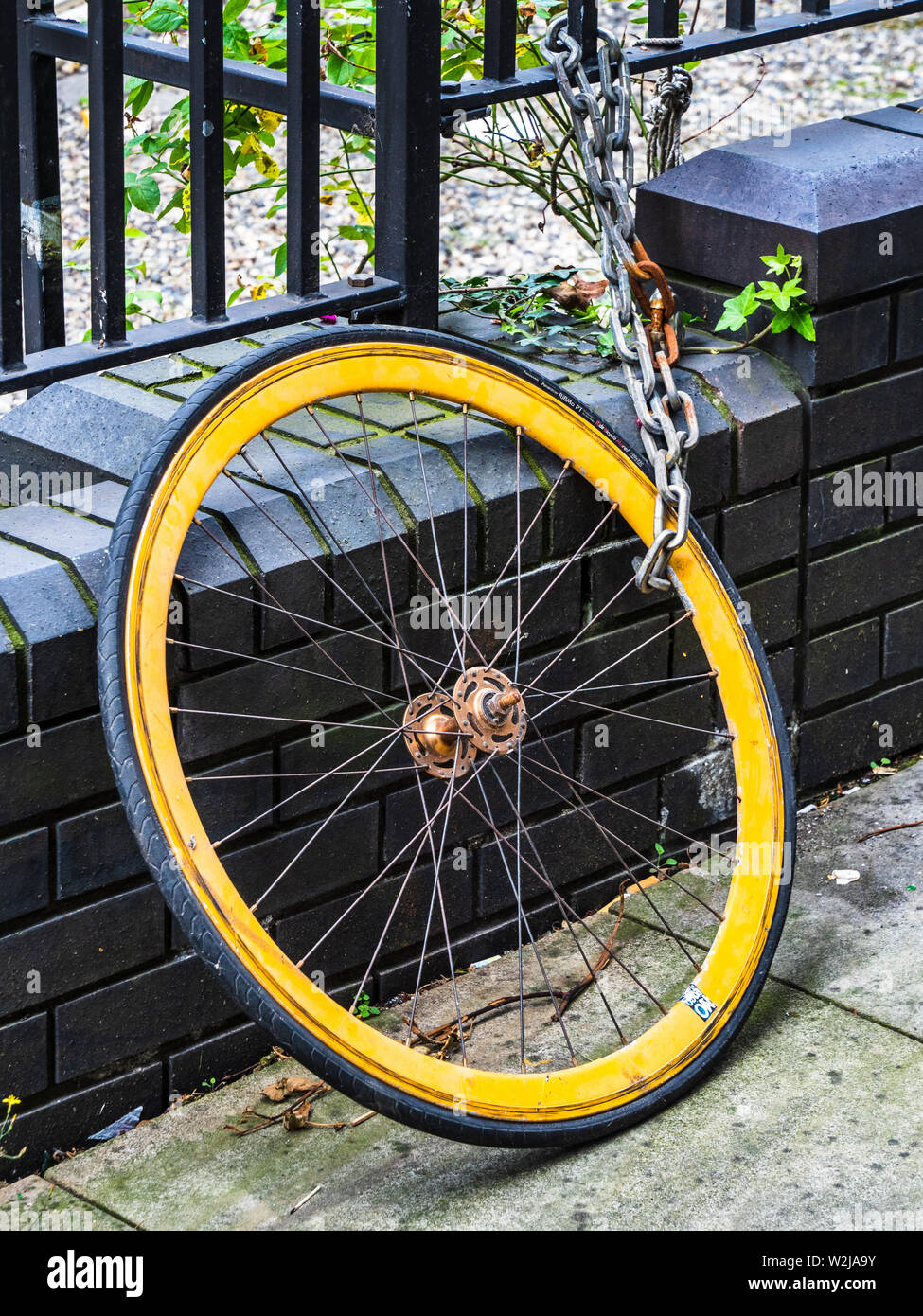 Bike wheel from a stolen bike - only the front wheel was locked, the rest of the bike was easily stolen. Stock Photo
