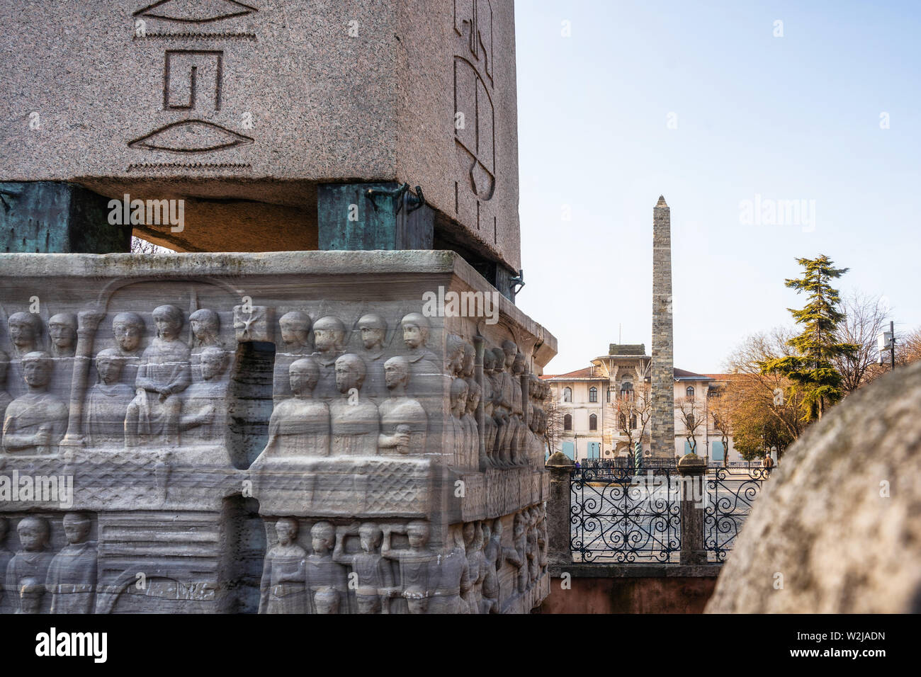 Details of the bas relief of the pedestal of Theodosius Obelisk and Walled Obelisk on background on Hippodrome of Constantinople in Istanbul, Turkey Stock Photo