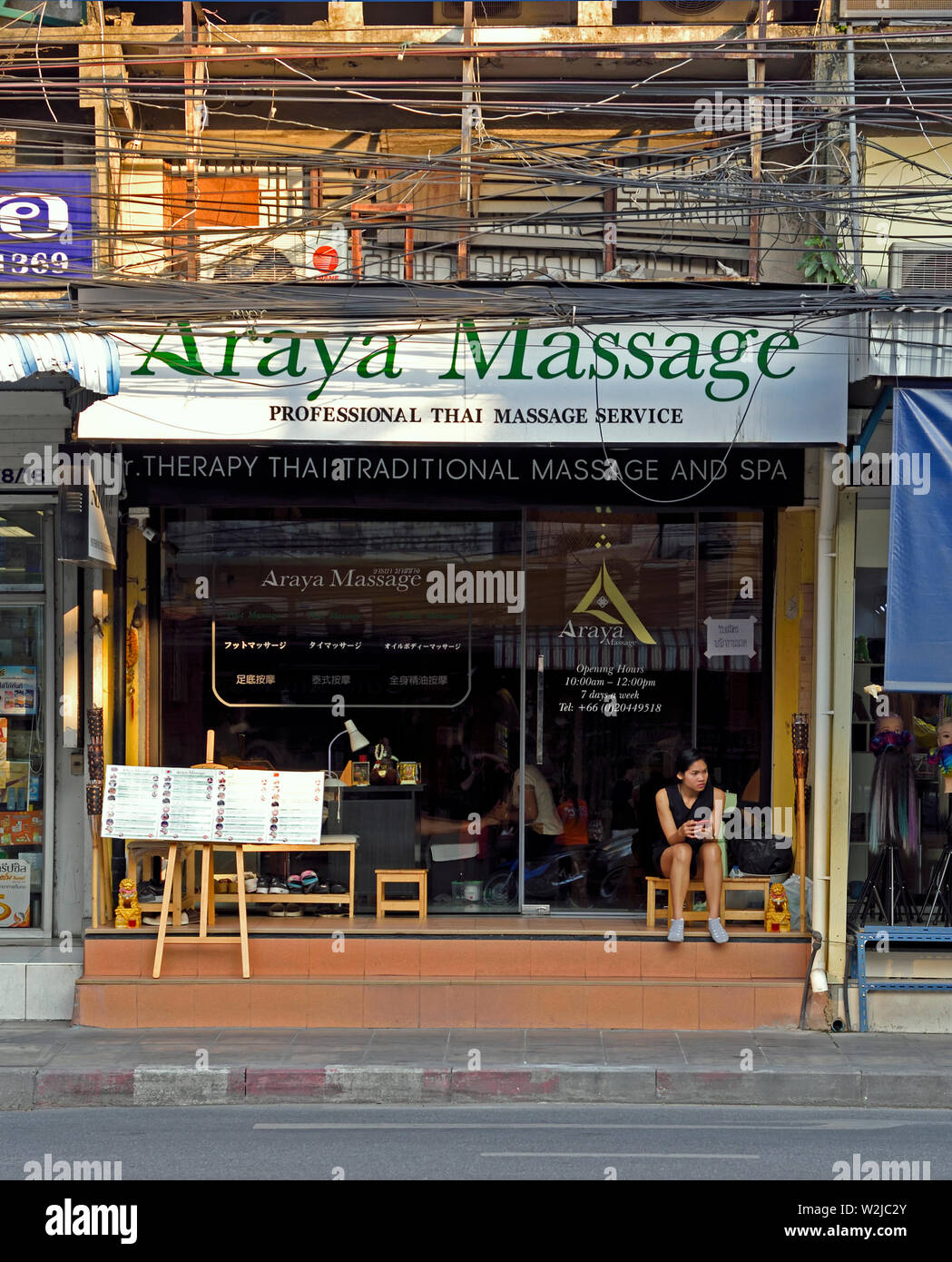 bangkok, thailand - january 13, 2019 : a young woman sitting in front of a  thai massage saloon on sukhumvit soi 55 ( thonglor Stock Photo - Alamy