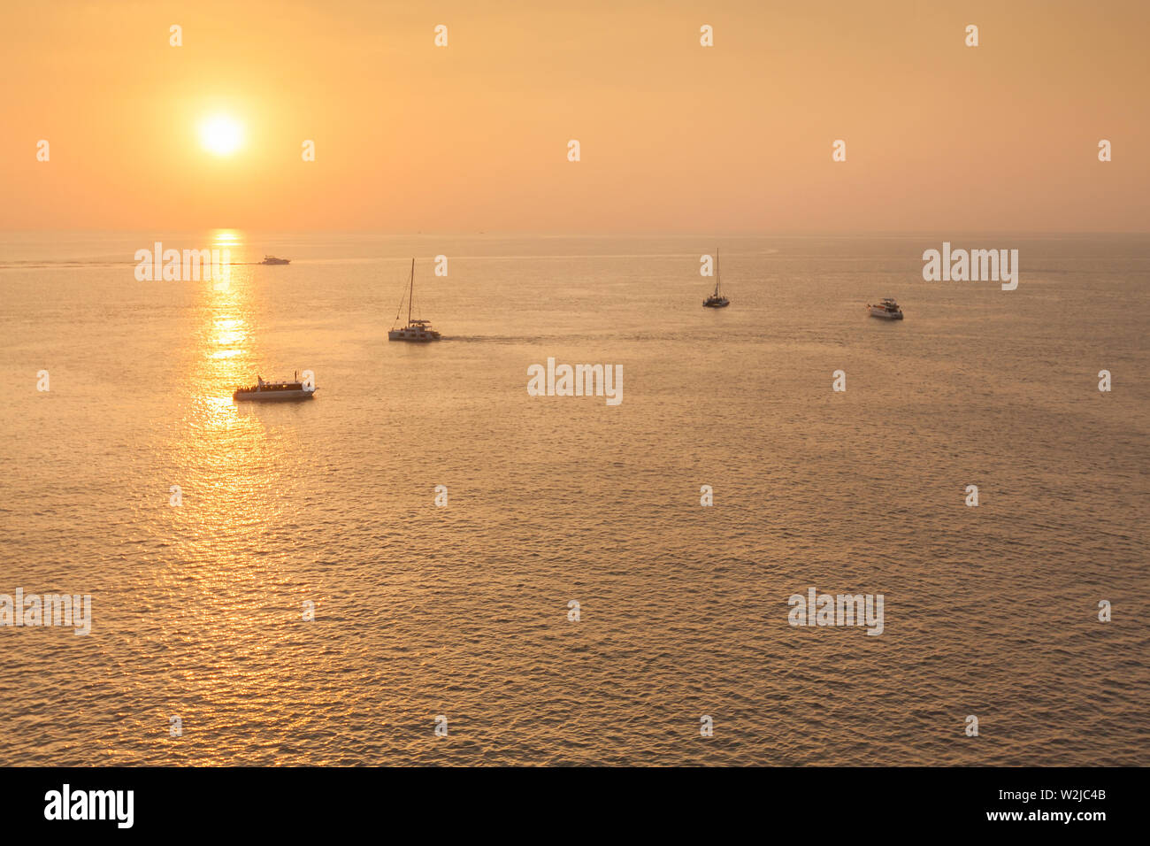 Yacht in the tropical sea at sunset Stock Photo - Alamy