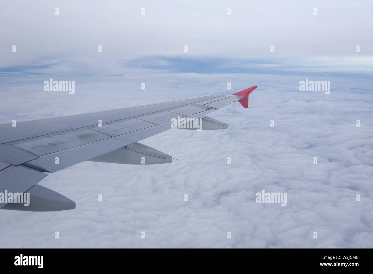 Wing of airplane flying above the clouds Stock Photo - Alamy