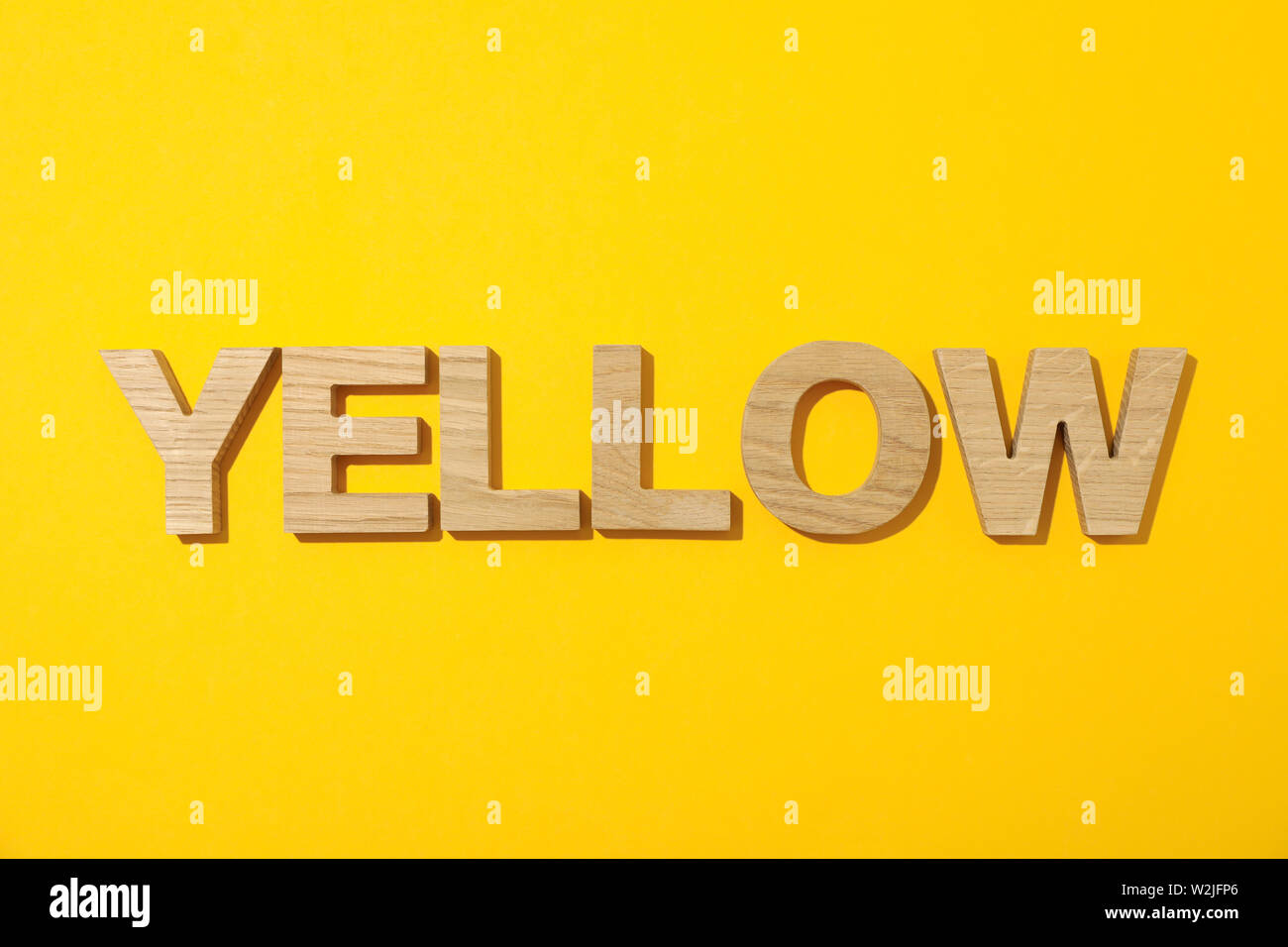 Word Yellow laid out in wooden letters on color background Stock Photo -  Alamy
