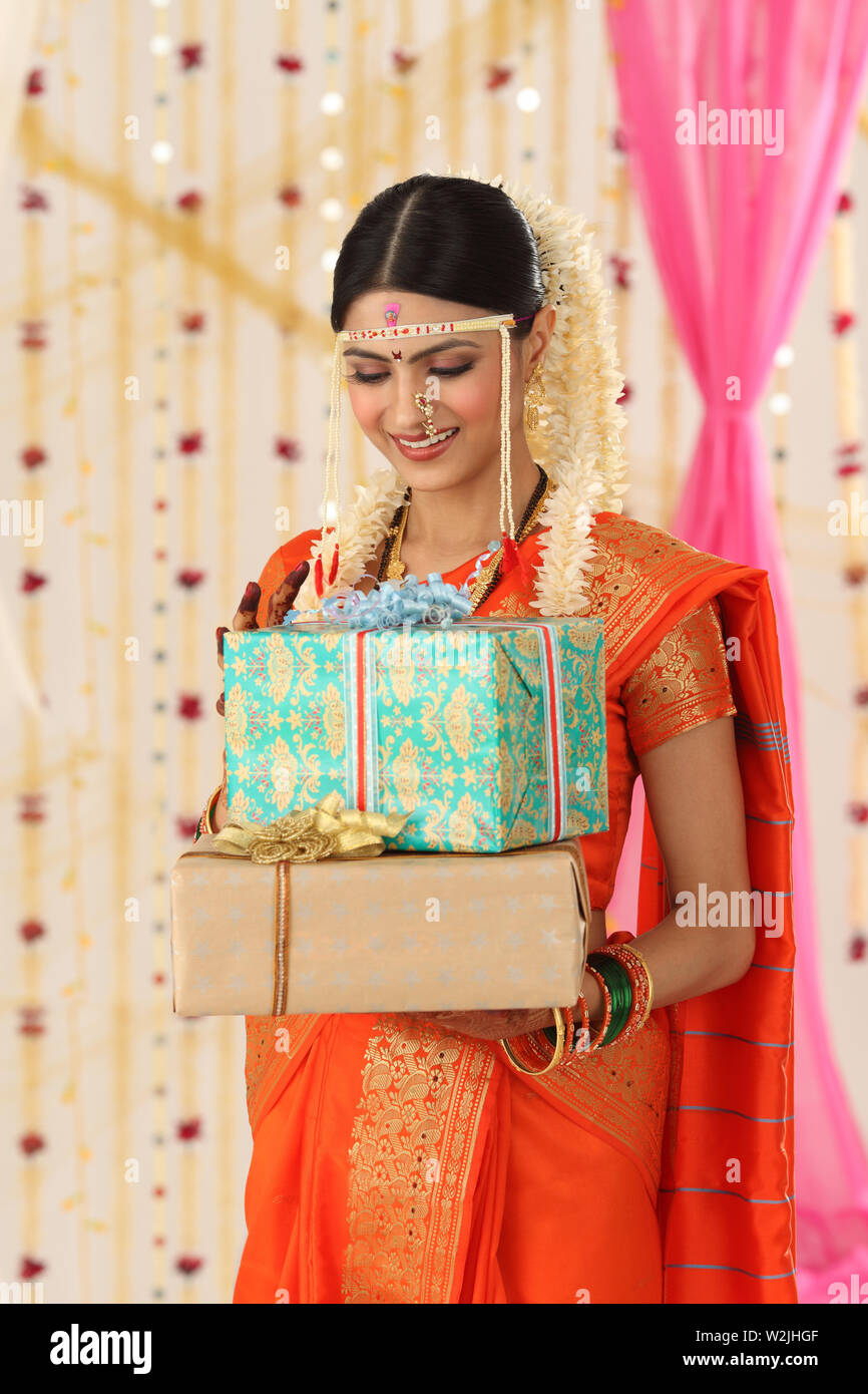 Indian young bride holding gift boxes Stock Photo
