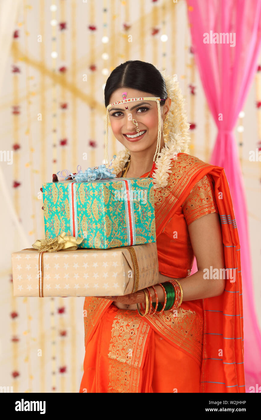 Portrait of an Indian bride holding gift boxes Stock Photo - Alamy