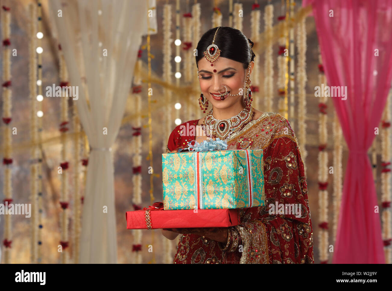 Indian bride holding gift boxes and smiling Stock Photo