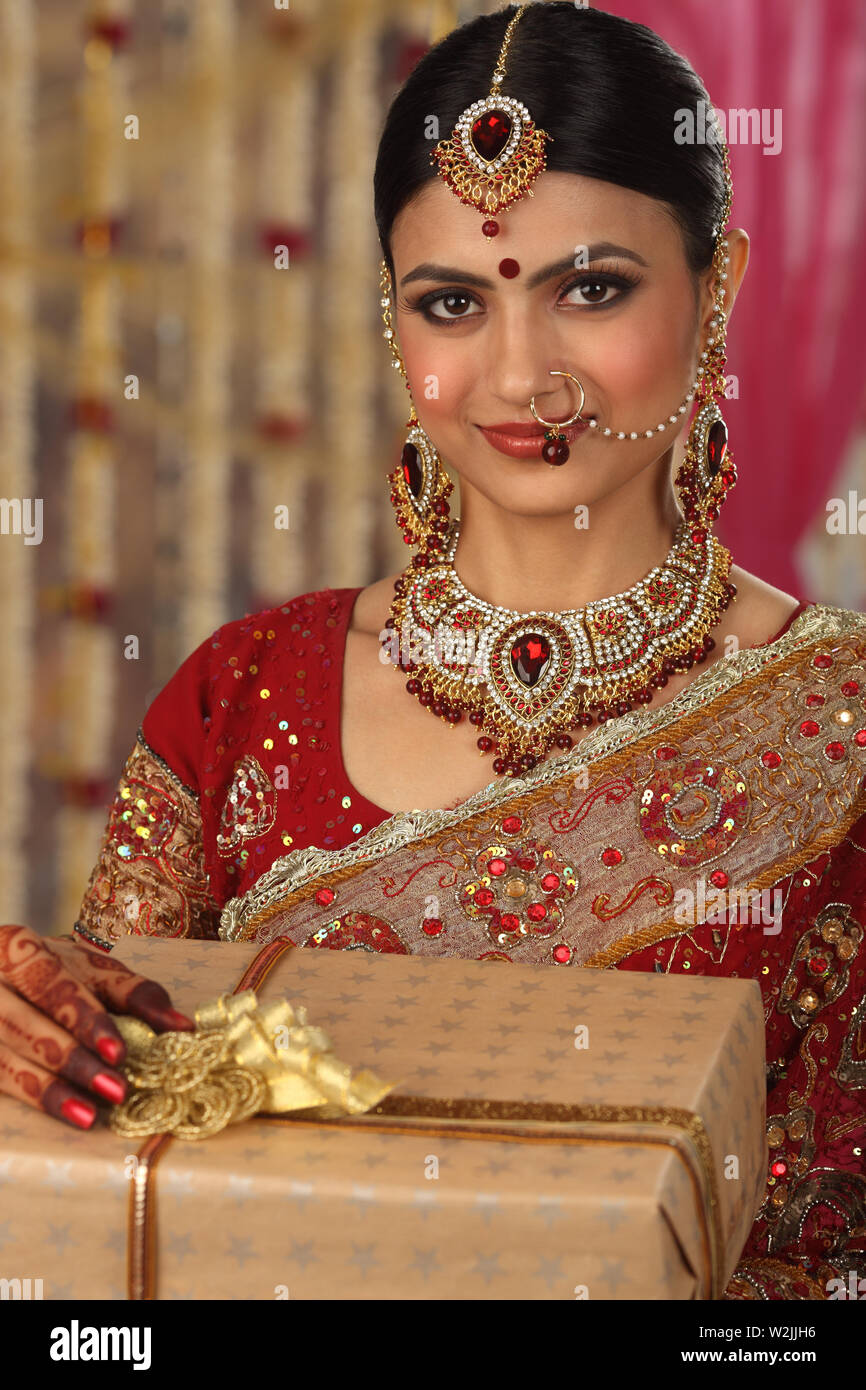 Indian bride holding gift boxes and smiling Stock Photo
