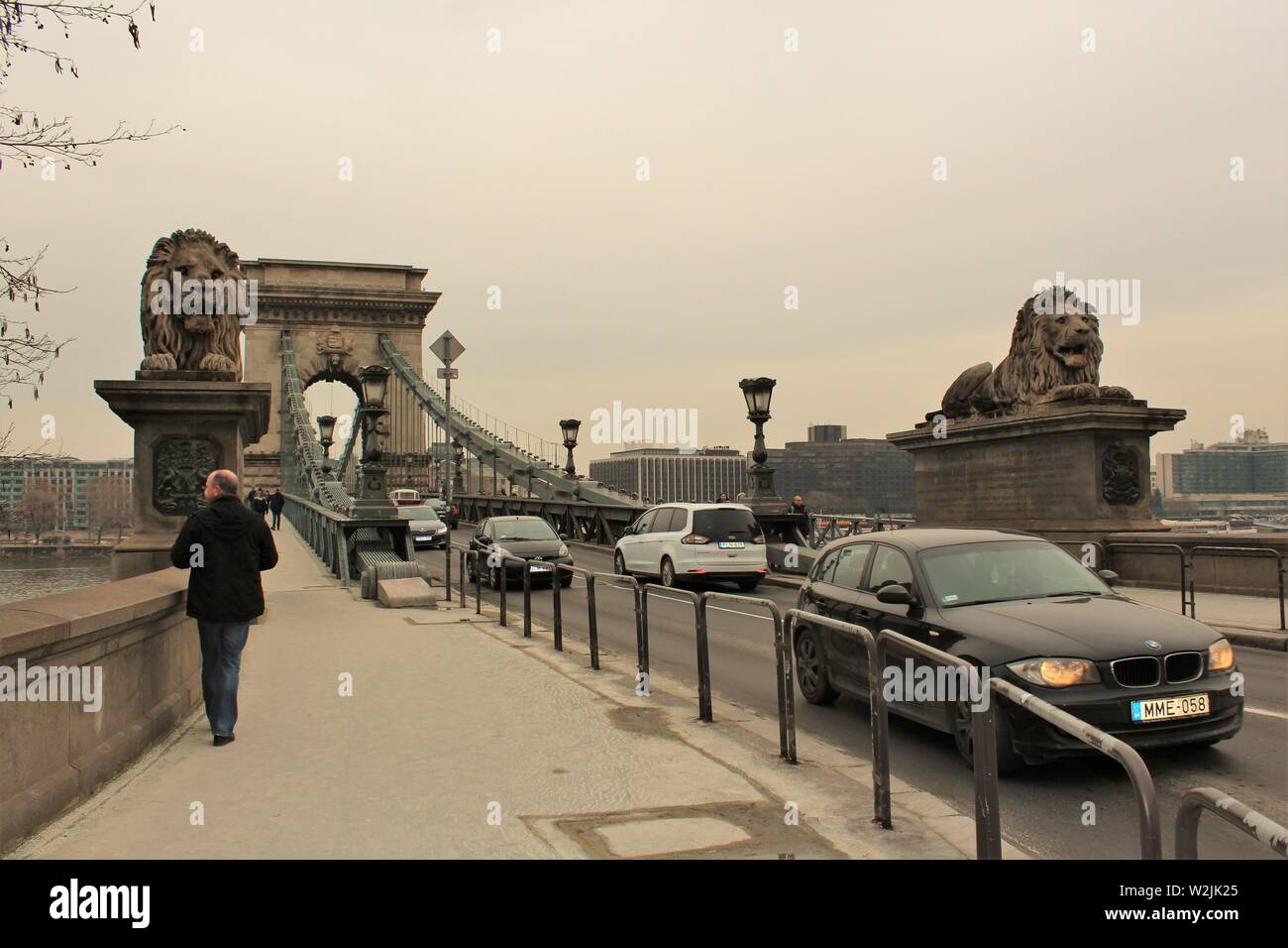 Pedestrians and vehicles in Budapest, using the Széchenyi chain bridge to cross over the Danube river between the Buda and Pest sides of the city. Stock Photo
