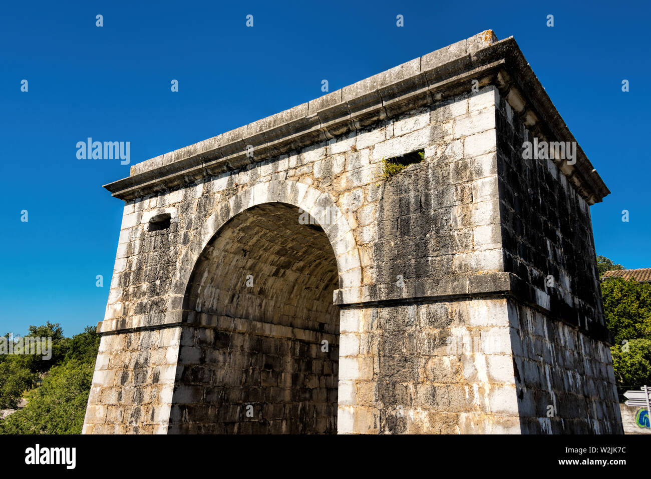 Old archway of a bridge in the village Ruoms at the river Ardeche in France Stock Photo