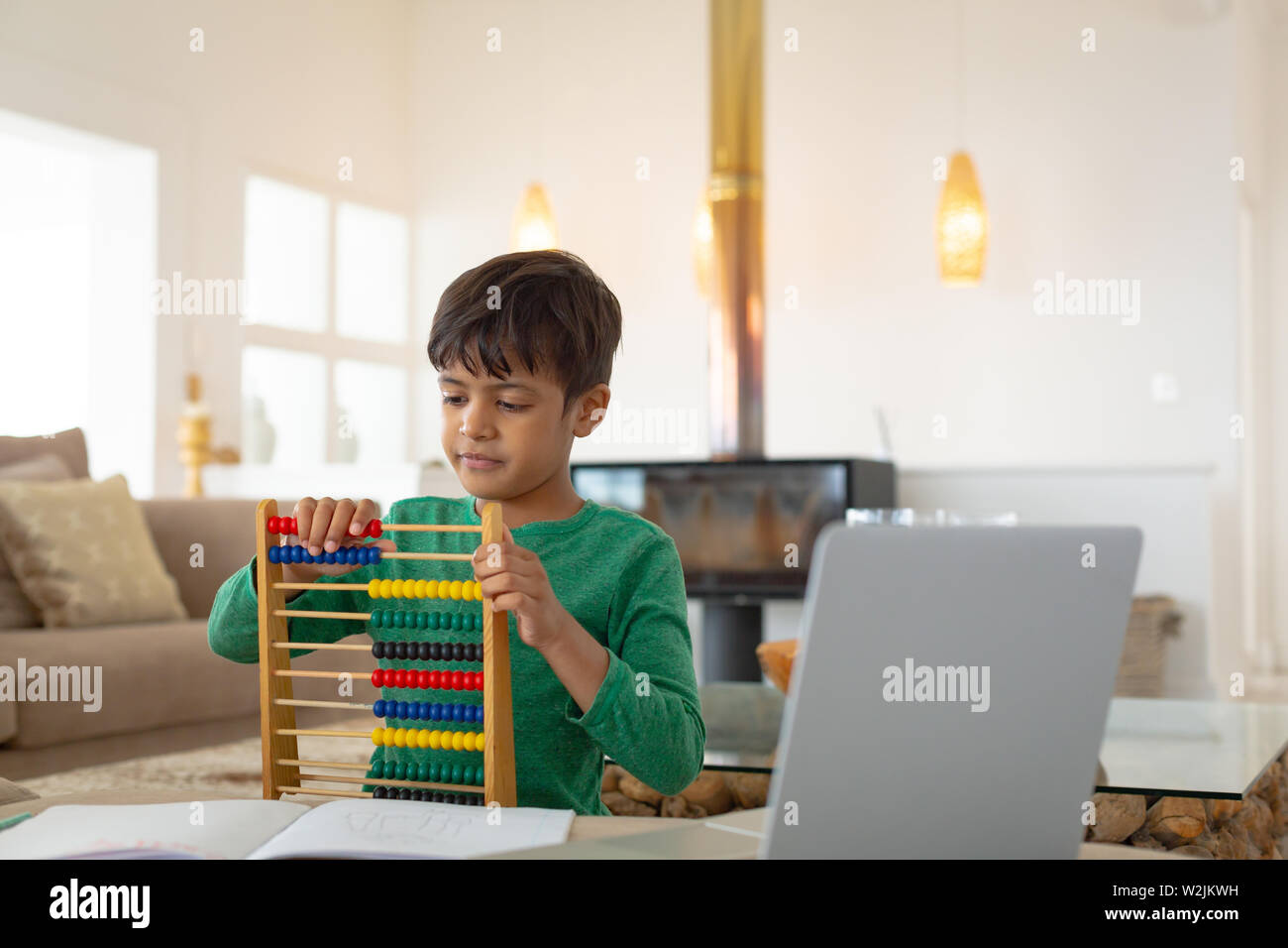Boy learning mathematics with abacus in a comfortable home Stock Photo