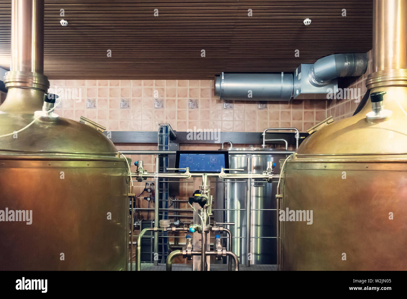 Close up of tanks and equipments in modern interior of brewery. Manufacturable process of brewage. Tanks and tubes in an up-to-date brewery. Mode and Stock Photo