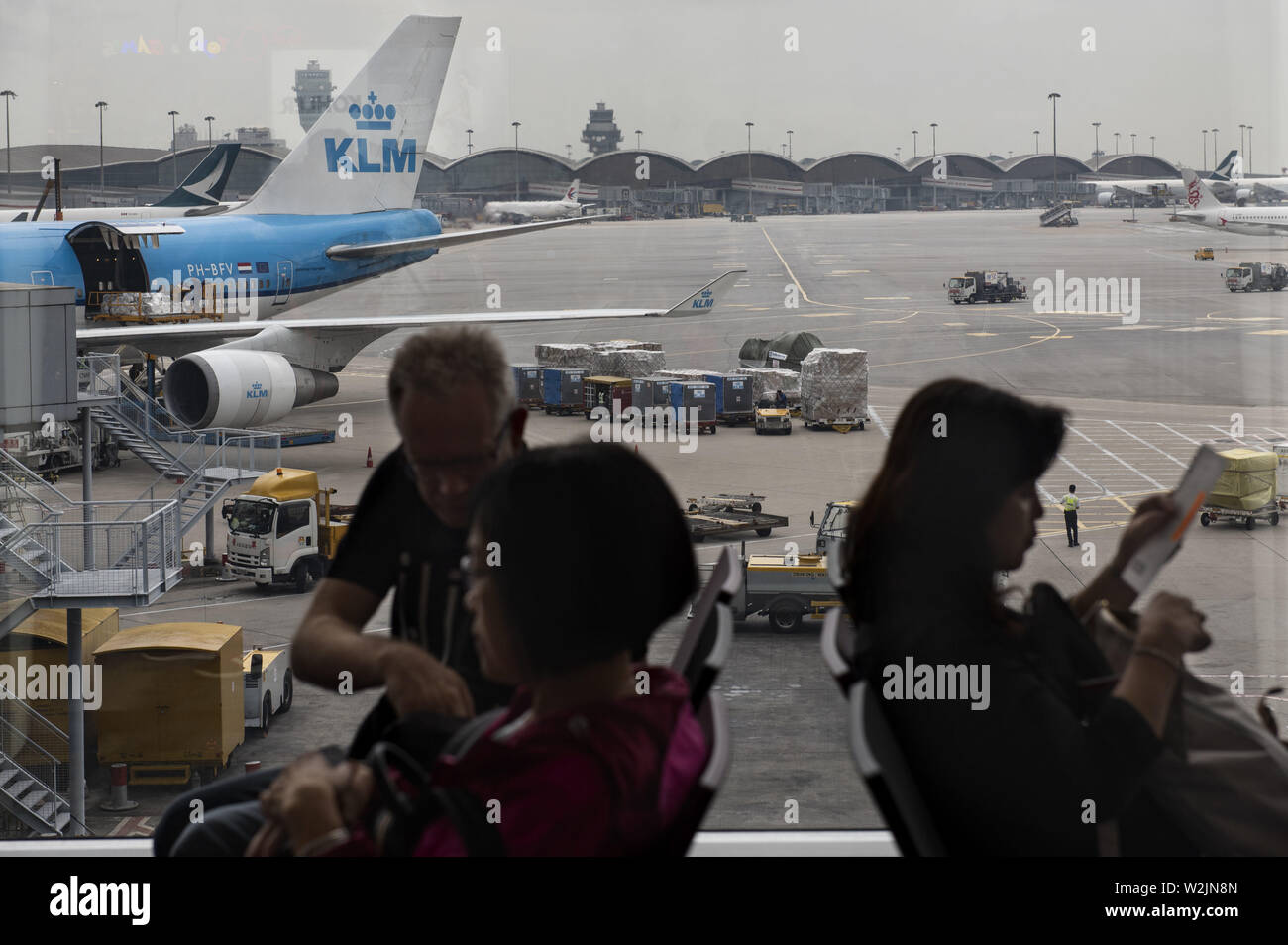 Hong Kong, China. 23rd May, 2019. Passengers seated at the waiting area at a boarding gate next to a KLM Royal Dutch Airlines plane at Hong Kong Airport runway. Credit: Budrul Chukrut/SOPA Images/ZUMA Wire/Alamy Live News Stock Photo