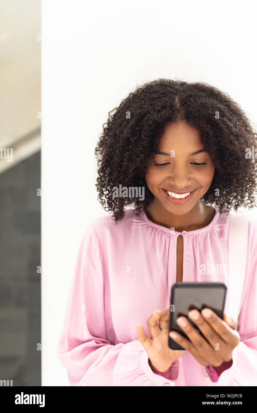 Young pretty African-american employee looking her phone Stock Photo