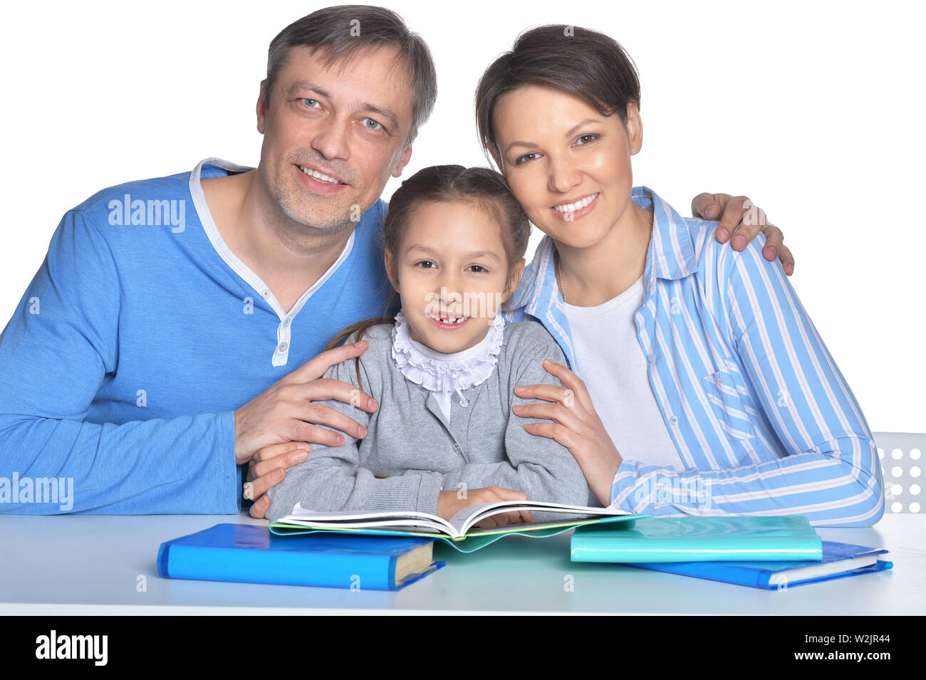 Portrait of happy parents and daughter doing homework Stock Photo - Alamy