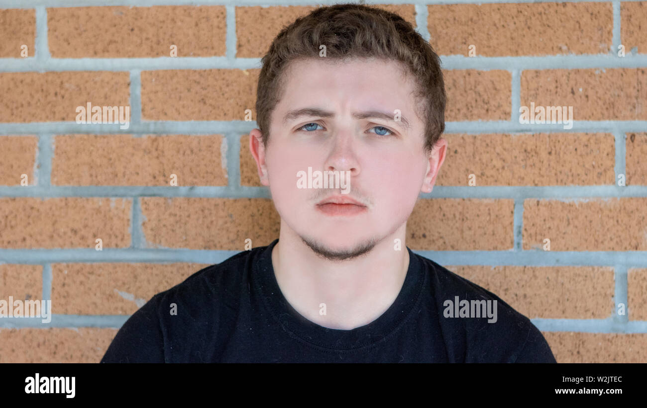 A Pretty Young Man With Pale Skin Short Curly Hair And Bright Blue