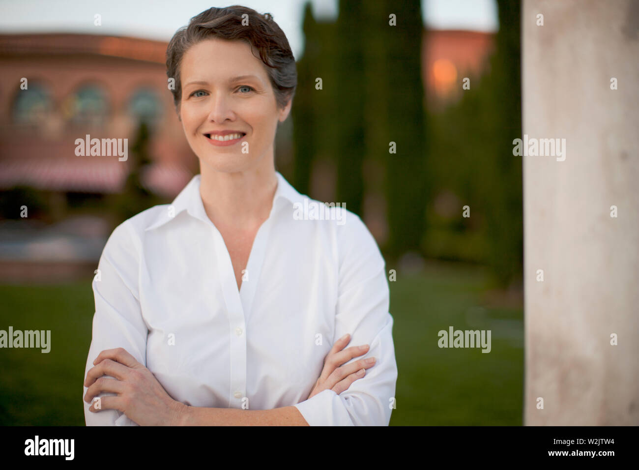 Portrait of a woman in front of a grand house. Stock Photo