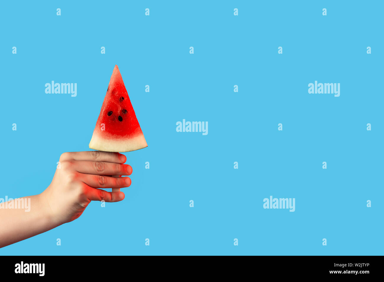 hand holding a piece of watermelon on a stick like ice cream on a blue background Stock Photo - Alamy hand holding a piece of watermelon on a stick like ice cream on a blue background Stock Photo - Alamy