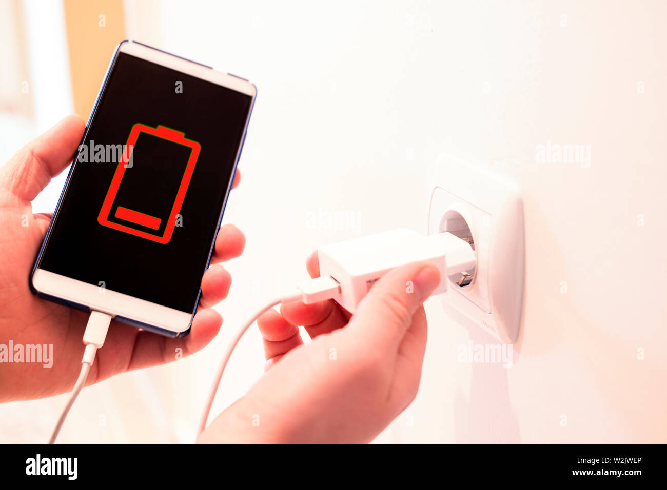 battery out of phone. phone charging from a wall outlet Stock Photo - Alamy